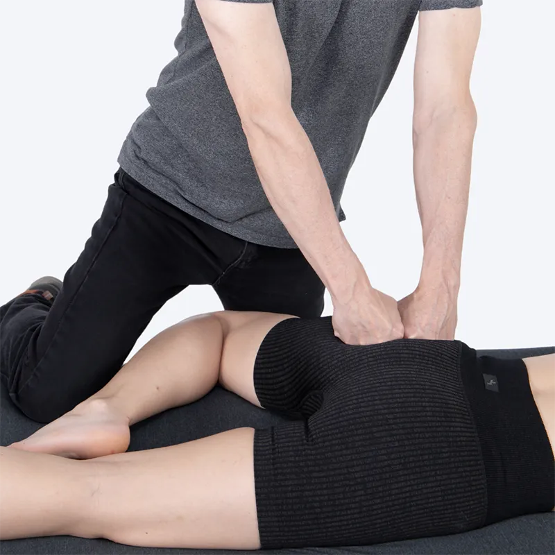 A massage therapist works on a client's gluteal muscles.