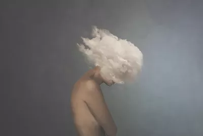 a nude person with their head literally in a cloud.